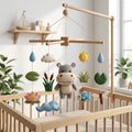 Handmade felt baby mobile featuring a central hippo, surrounded by lotus flowers, fish, dragonfly, pond plants, and raindrops hanging from a wooden frame over a baby crib, pond-themed nursery decor