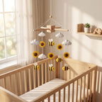 Handmade felt baby mobile featuring yellow bees, sunflowers, and clouds hanging over a wooden crib, perfect for nature-themed nursery decor