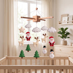 Handmade felt baby mobile featuring Santa Claus, reindeer, snowmen, and Christmas trees hanging over a wooden baby crib, Christmas themed nursery decor