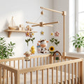 Handmade felt cow farm baby mobile with cow, sheep, chick, baby bottle, sunflower, flowers, and barn hanging above a wooden crib.