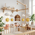 Handmade felt farm baby mobile featuring a barn, cow, pig, sheep, horse, chicken, clouds and suns above a wooden crib.