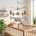 Personalized felt transportation baby mobile with a bus, taxi, ambulance, police car and fire truck hanging above a wooden crib.