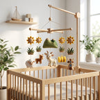 Handmade felt farm baby mobile with goat, sheep, horse, mountains, sunflowers, hay bale and windmill above a wooden crib.