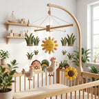 Handmade felt rooster baby mobile with rooster, hen, barn, tractor, sunflower, sunshine and grass above a wooden crib.