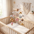 Handmade felt baby mobile featuring cupcakes, donuts, croissants, and ice cream cones, with a 'Sweet Treats' sign, hanging over a wooden baby crib