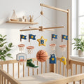 Personalized felt basketball baby mobile with hoops, jersey, sneaker and basketball hanging above a wooden crib.