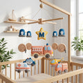 Personalized felt emergency vehicle baby mobile with a fire truck, ambulance, police car and rescue helicopter hanging above a wooden crib.
