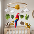 Handmade felt baby mobile featuring a vibrant parrot, leopard, rhinoceros, tiger, and sloth, surrounded by tropical leaves and the sun, hanging over a wooden baby crib, jungle-themed nursery decor.